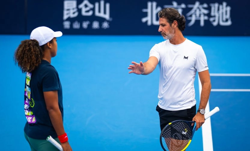 Patrick Mouratoglou giving technical instructions to Naomi Osaka on a blue hard court