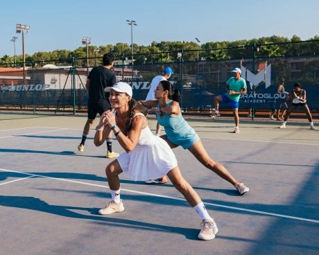 Tennis players doing warm-up exercises on court during training.