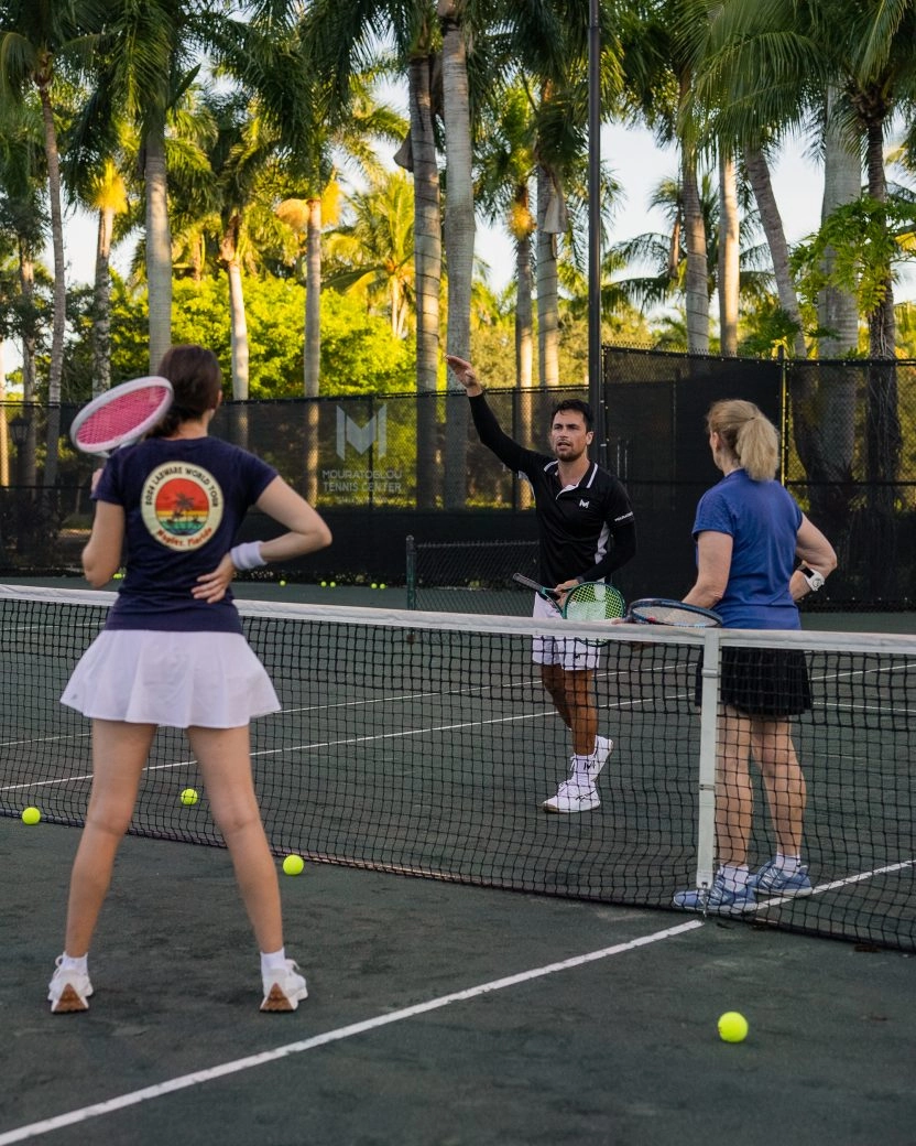 Tennis coach giving instructions to a group of players at Mouratoglou Tennis Center Naples, Florida