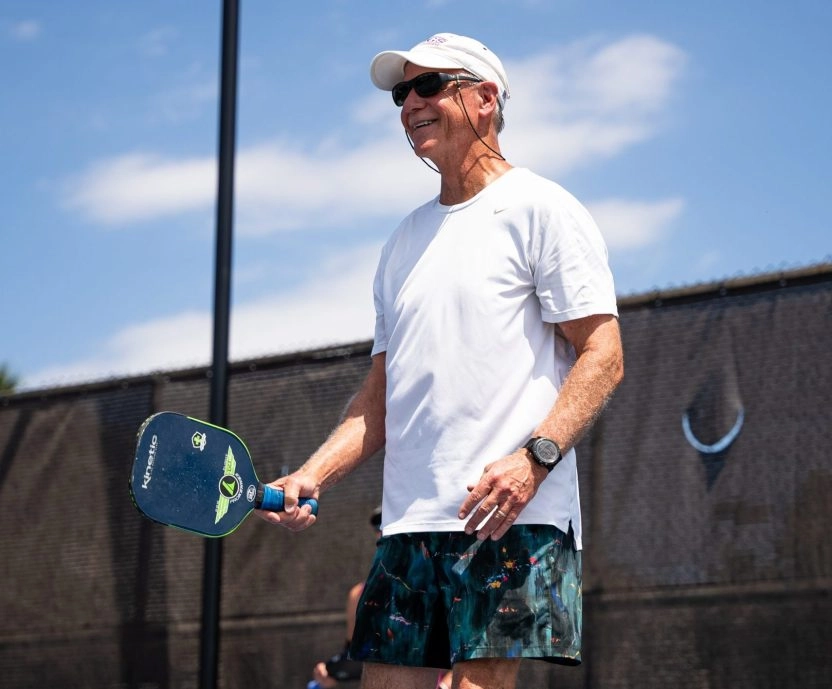 Un adulte joue au pickleball sur un court extérieur au Mouratoglou Tennis Center à Horseshoe Bay.
