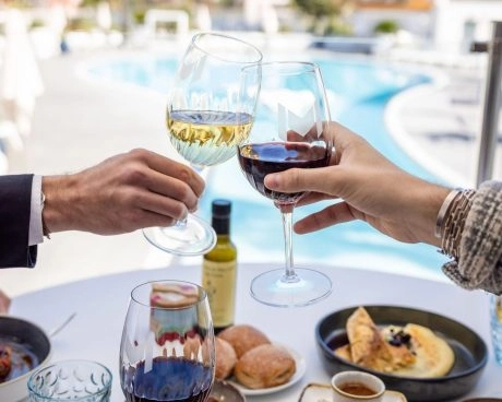 2 personnes qui trinquent au bord de la piscines du restaurant l'emblème
