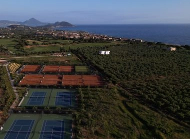 Aerial view of tennis courts near the coastline surrounded by nature.