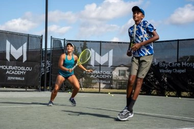 Teen tennis players reacting to a shot during doubles training at Mouratoglou Academy Zephyrhills