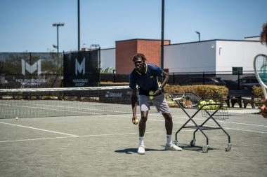 Tennis coach ball feeding during training at Mouratoglou Academy