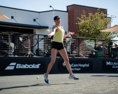 Female tennis player hitting a forehand during training on an outdoor court