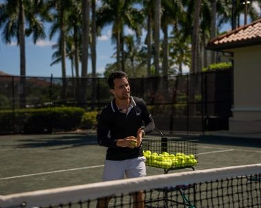 Tennis coach addressing players during a training session at Mouratoglou Tennis Center Naples at The Ritz-Carlton Naples, Tiburón.