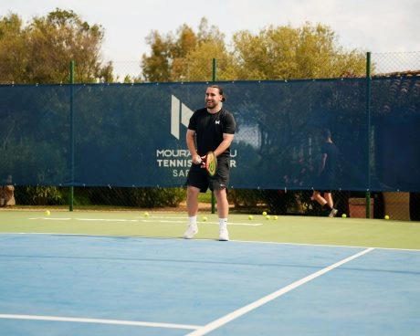 Tennis player preparing to return a ball on an outdoor hard court at Mouratoglou Tennis Center