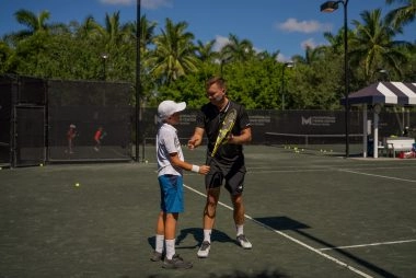 Young tennis player listening to coach instructions at Mouratoglou Tennis Center Naples, Florida