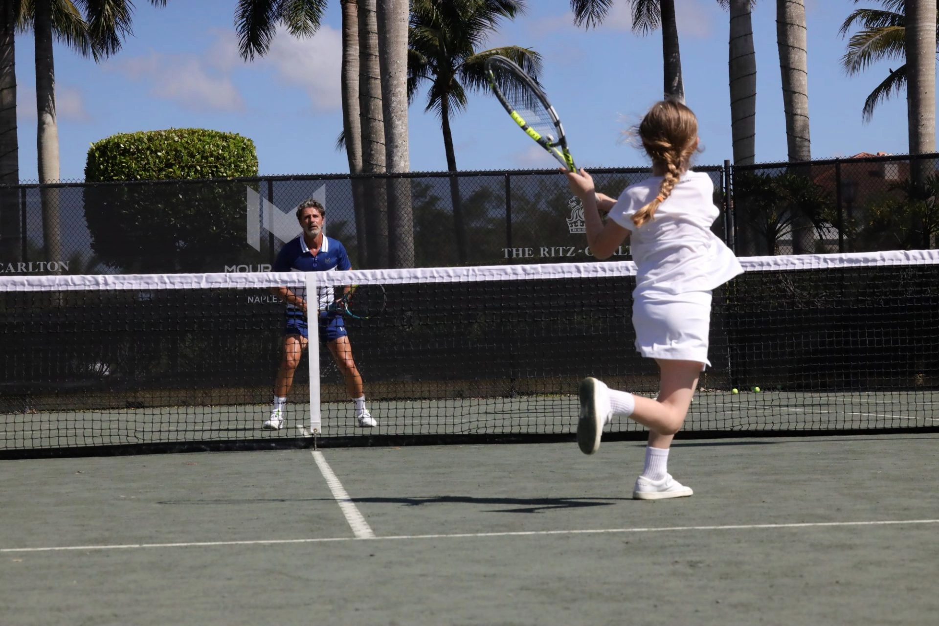 Children playing tennis on clay courts during a junior training session at Mouratoglou Tennis Center Naples at The Ritz-Carlton Naples, Tiburón.