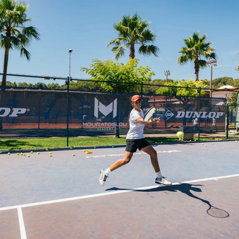 Young tennis player hitting a forehand during training