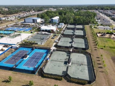Aerial view of a large sports complex with multiple tennis and pickleball courts