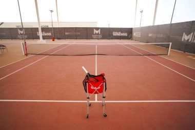 Wilson tennis ball bag placed on the court at Mouratoglou Tennis Center Hudayriyat Island in Abu Dhabi, symbolizing professional training and performance.