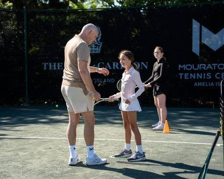 Coach explaining a movement during a semi-private lesson at Mouratoglou Tennis Center Amelia Island