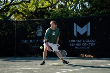 Adult playing tennis on the courts of Mouratoglou Tennis Center Amelia Island