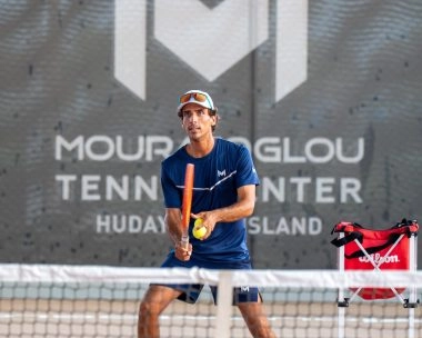 Coach Jaime at Mouratoglou Tennis Center Hudayriyat Island in Abu Dhabi, preparing to return a ball during a tennis session.