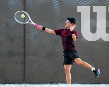 Tennis player preparing to receive a ball on the courts of Mouratoglou Tennis Center Hudayriyat Island in Abu Dhabi, focusing on anticipation and control.