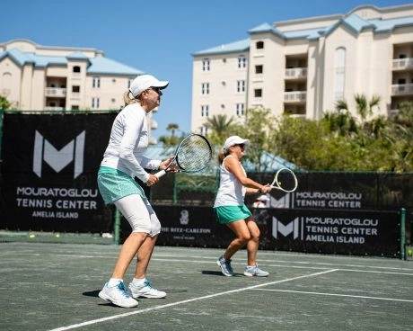 Two women playing tennis during a clinic at Mouratoglou Tennis Center Amelia Island