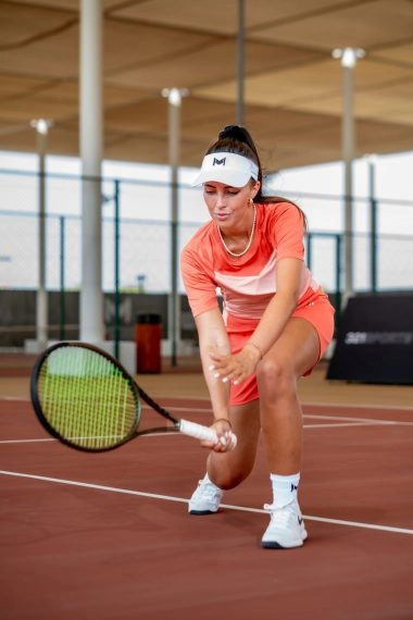 Female tennis player demonstrating a swing technique with her racket at Mouratoglou Tennis Center Hudayriyat Island in Abu Dhabi.