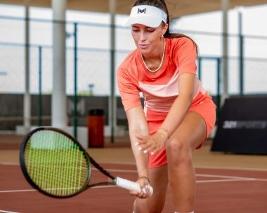 Female tennis player demonstrating a swing technique with her racket at Mouratoglou Tennis Center Hudayriyat Island in Abu Dhabi.