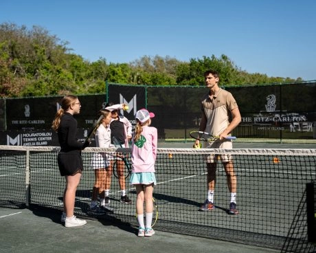 Coach talking to a group of children on the courts of Mouratoglou Tennis Center Amelia Island