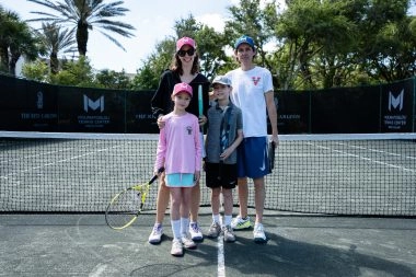 Family posing on the tennis courts of Mouratoglou Tennis Center Amelia Island 📖 Description (champ media)