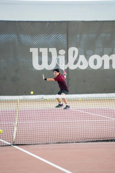 Tennis player on the court at Mouratoglou Tennis Center Hudayriyat Island in Abu Dhabi, training under the sun in a world-class coastal setting.