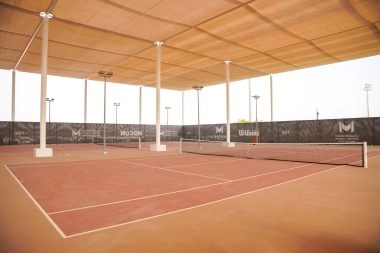 Mouratoglou Tennis Center Hudayriyat Island court overlooking the Arabian Gulf under the soft Abu Dhabi light.