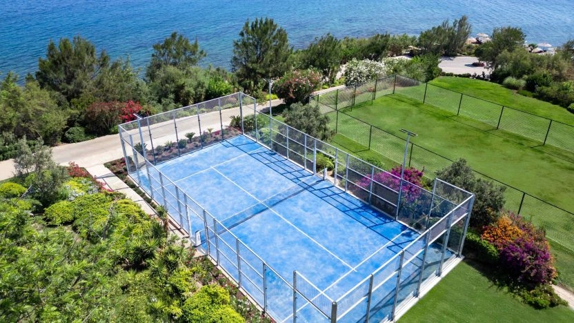 Blue padel court in Bodrum surrounded by greenery and sea views