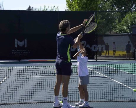 Patrick Mouratoglou teaching a young player proper volley technique at the net
