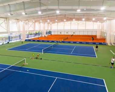 Indoor tennis facility with blue and clay courts at Mouratoglou Tennis Academy Malaysia