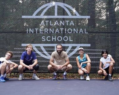 Federico avec les élèves de Tennis Etudes assis devant les bâches Mouratoglou à la Mouratoglou Academy d'Atlanta.