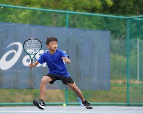 Young tennis player preparing a forehand on an outdoor court.