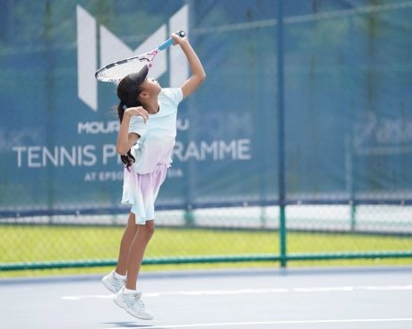 Young player jumping to hit an overhead shot at the Mouratoglou Tennis Programme