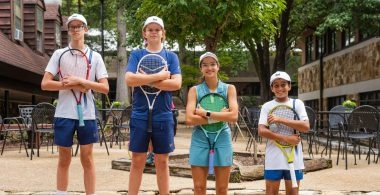 Groupe de jeunes joueurs de tennis tenant des raquettes sur le campus de l'Atlanta International School.