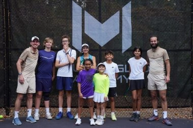 Des joueurs de tennis posant devant les bâches « M » Mouratoglou à la Mouratoglou Academy d'Atlanta.