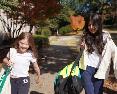 Two young tennis players walking on campus with their tennis bags at Atlanta International School