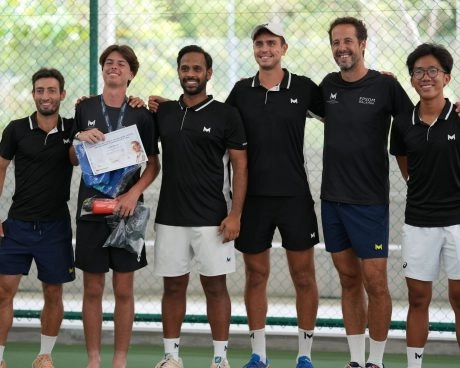 Group of tennis students and coaches posing together during a Tennis & School Program event