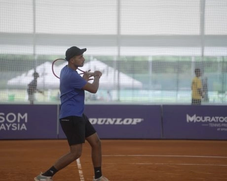 Player hitting a forehand on an indoor clay court at Epsom Malaysia.