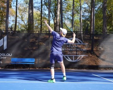 Jeune joueur de tennis effectuant un service à la Mouratoglou Academy d'Atlanta