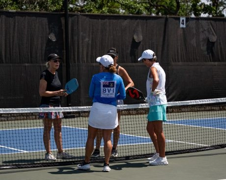 Quatre joueurs échangent au filet d’un court de pickleball extérieur au Mouratoglou Tennis Center à Horseshoe Bay.