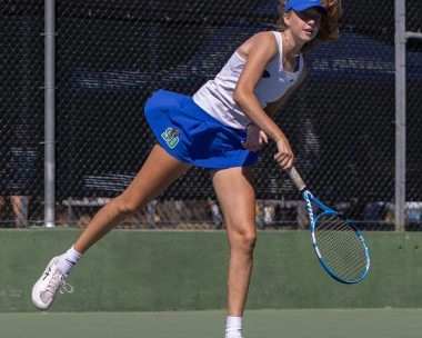 Female tennis player serving on an outdoor hard court