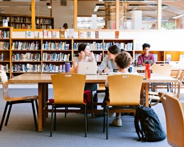 Students studying and collaborating in a library or study space at Mouratoglou Academy San Francisco.