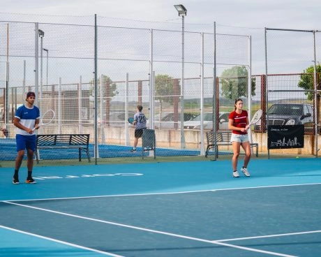 Two tennis players on court at Mouratoglou Tennis Center Calatrava, practicing or playing a point on blue hard courts