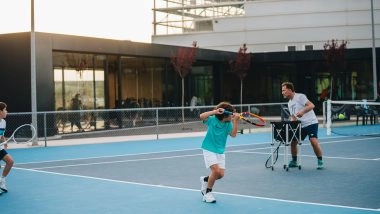 Children training with a coach on blue tennis courts at Mouratoglou Tennis Center Calatrava