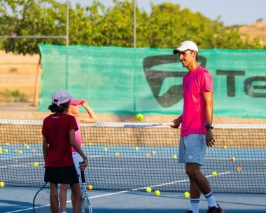 Semi‑private tennis lesson with a coach on a sunny outdoor hard court at Mouratoglou Tennis Center Calatrava