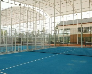 Semi-indoor padel court at Mouratoglou Tennis Center Bali with tropical scenery visible outside.