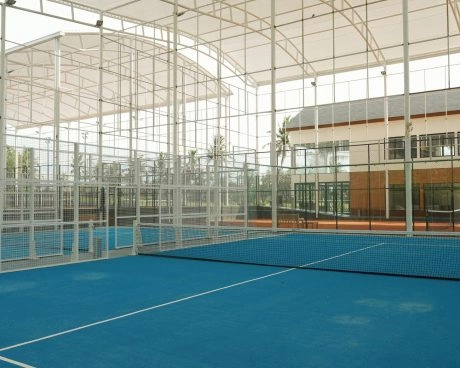 Semi-indoor padel court at Mouratoglou Tennis Center Bali with tropical scenery visible outside.