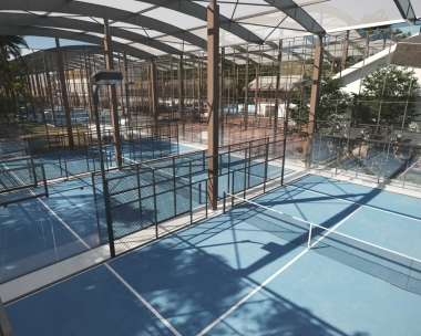 Semi-indoor padel court at Mouratoglou Tennis Center Bali with tropical scenery visible outside.