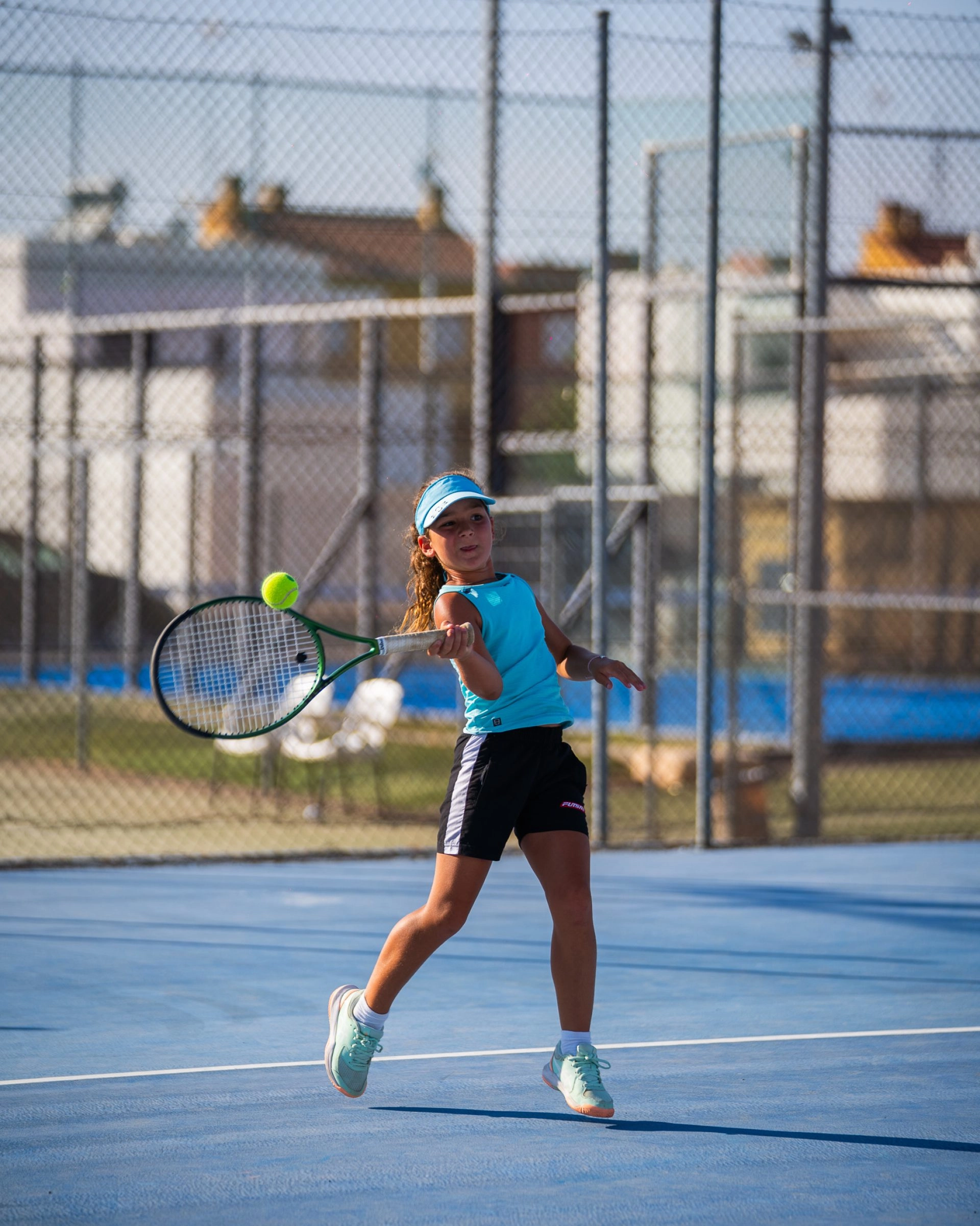 Junior tennis player hitting a shot on an outdoor court at Mouratoglou Tennis Center Calatrava.