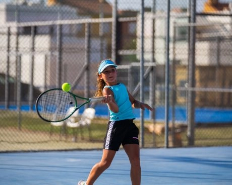 Junior tennis player hitting a shot on an outdoor court at Mouratoglou Tennis Center Calatrava.